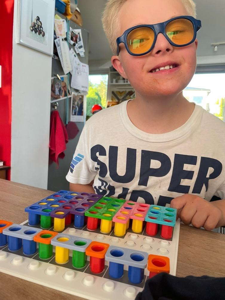 Gutt med Downs syndrom gjør mattelekser med hjelp av konkreter