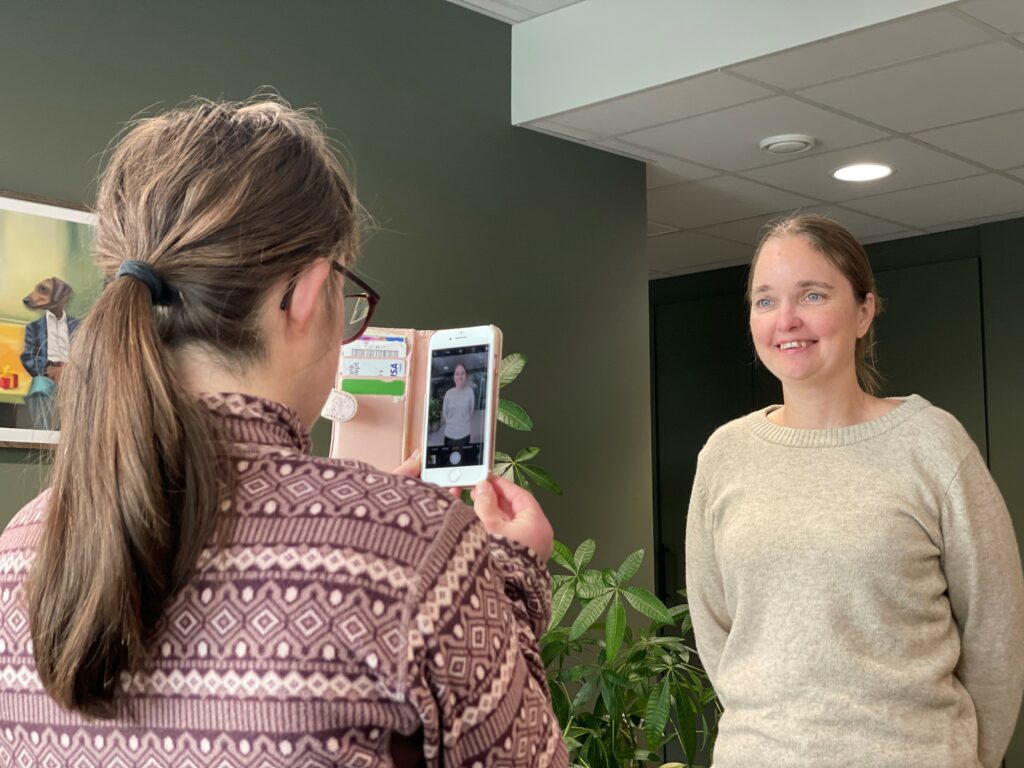 En fotograf tar bilde av en smilende kvinne