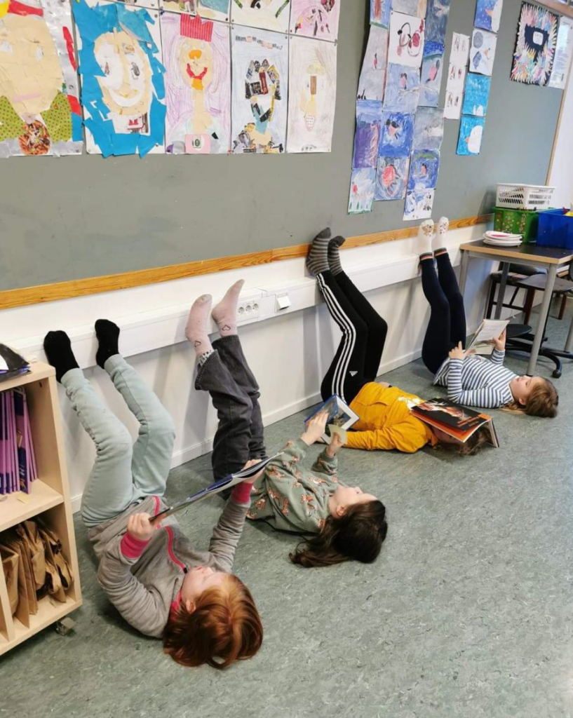 4 barn leser bøker på en kreativ måte