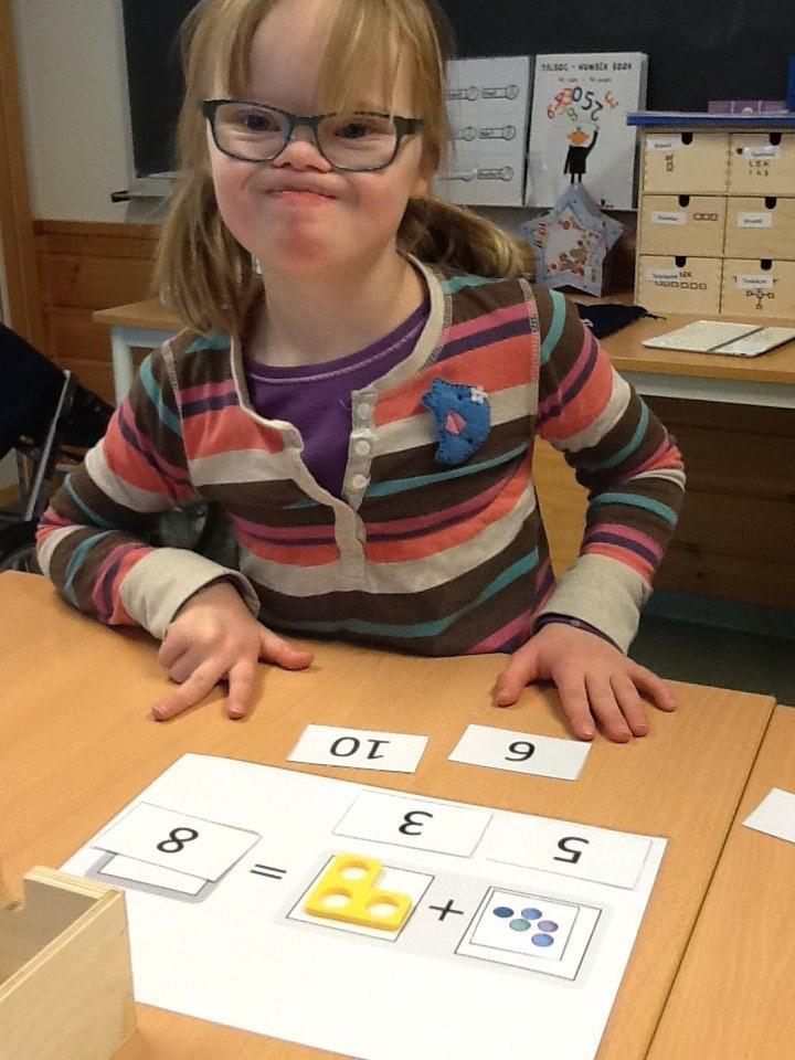 Jente med Downs syndrom løser mattestykke med hjelp av bilder og symboler
